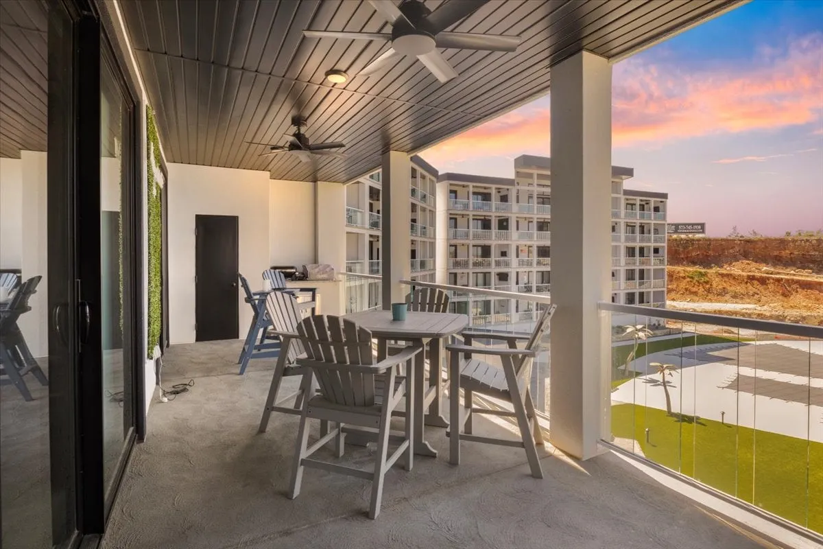 An inviting outdoor balcony with a dining set and railing, overlooking a picturesque landscape. The setup encourages alfresco meals and leisurely evenings spent enjoying sunset views, ideal for family BBQs and gatherings described in the section.