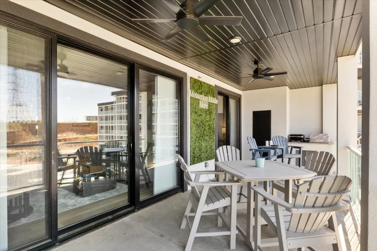 Featuring a cozy outdoor seating area next to a stylish green wall and a designated grill area, this image radiates comfort and sociability. The ambient lighting hints at beautiful sunsets, making the space ideal for casual dining, social gatherings, and relaxed evenings outdoors.